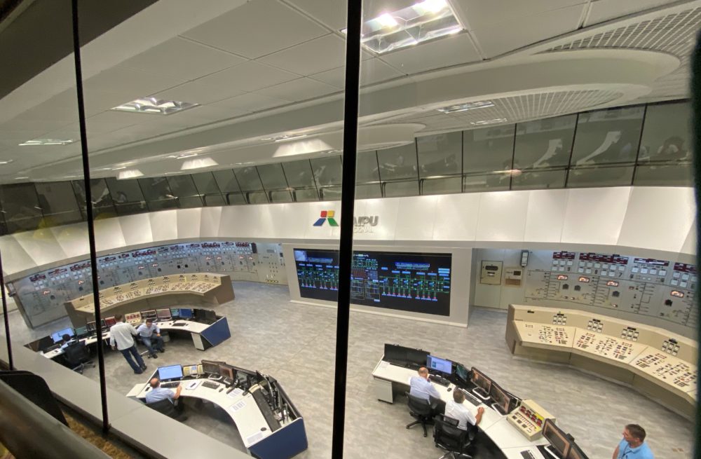 Foto do alto da sala de controle da usina. A mesa do meio é ocupada alternadamente pelo Brasil e pelo Paraguai